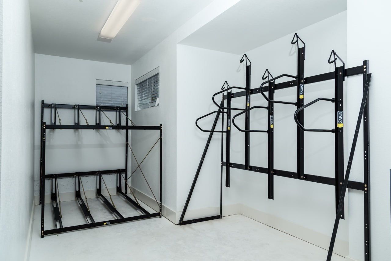 Interior community fitness room with black metal gym racks and pull-up bars.