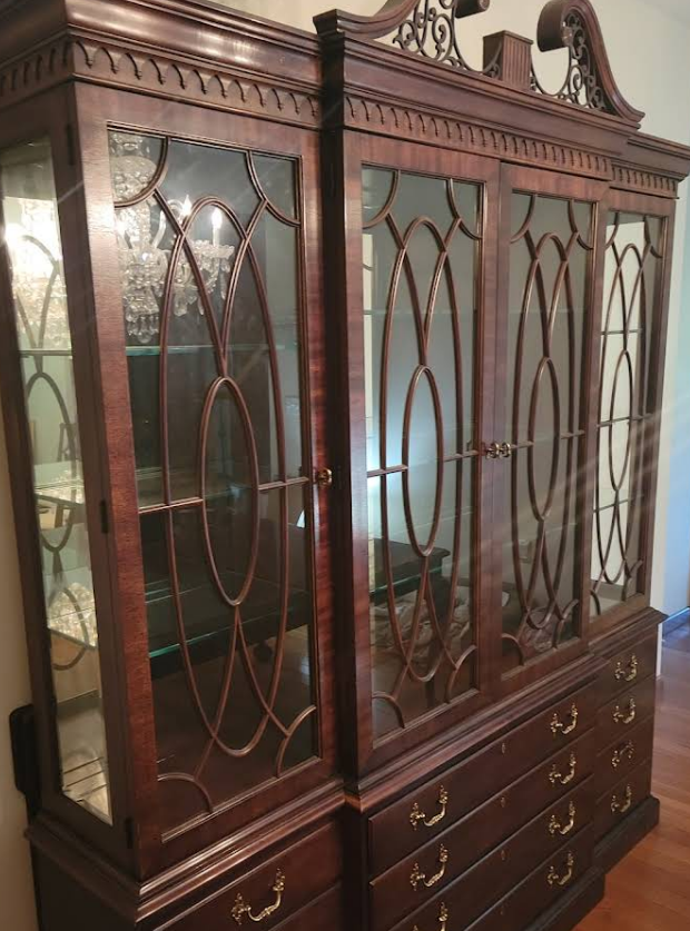 Dark wood china cabinet with glass doors, drawers, and ornate carvings.