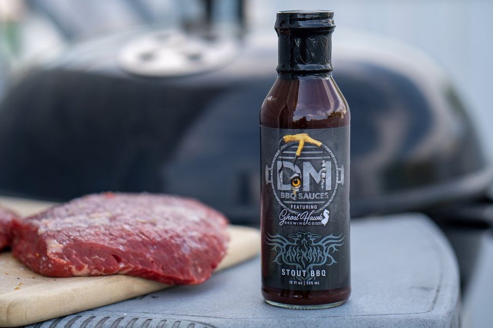 a bottle of stout bbq sauce next to a piece of meat