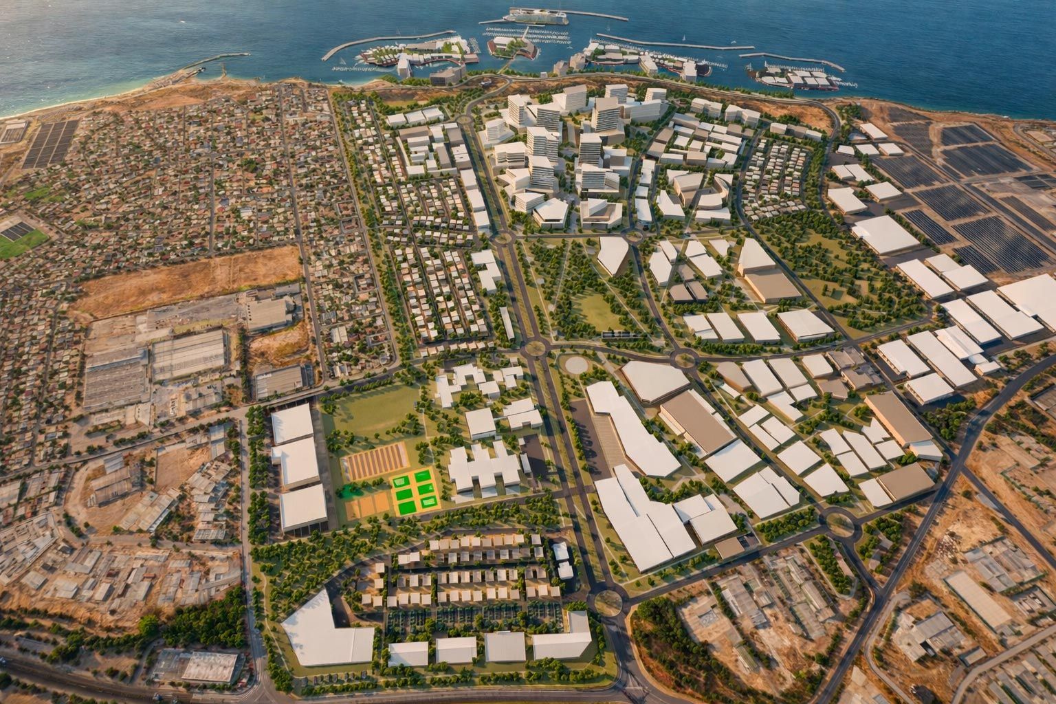 An aerial view of a planned urban development featuring modern buildings, green spaces, and sports courts near a coastline.