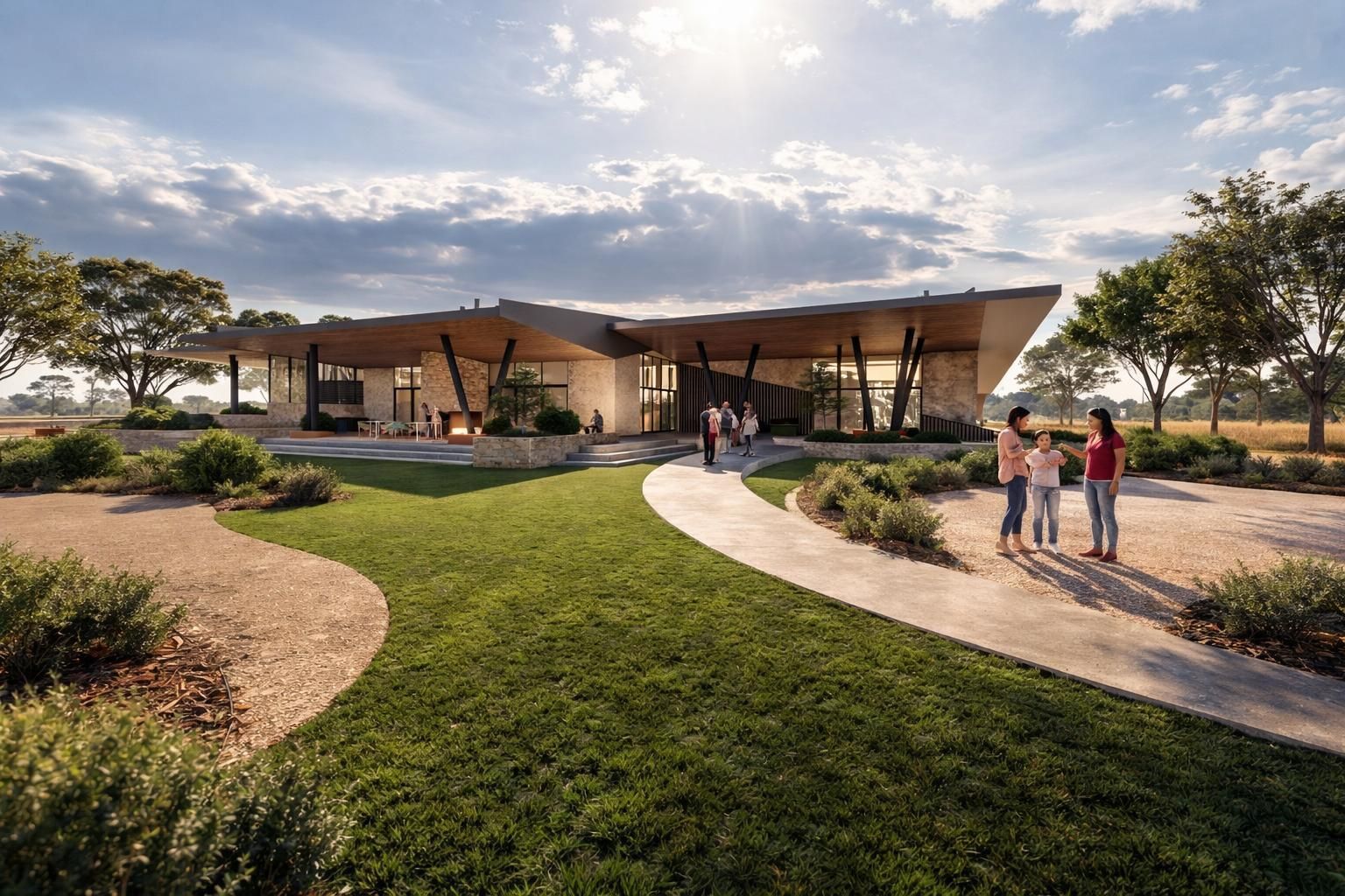 Modern stone building with a wide, cantilevered roof and curved walkway in a sunny, landscaped park setting.