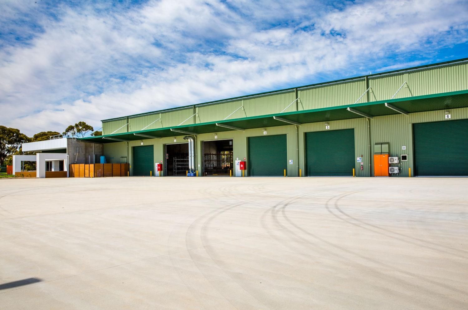 A peaceful garden with lounge chairs, a wooden gazebo, and people relaxing under a large shade sail.