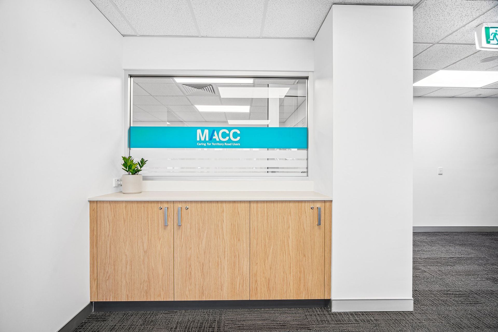 A chic salon interior featuring a central double-sided mirror, beige swivel chairs, a curved bench, and soft pink decor.