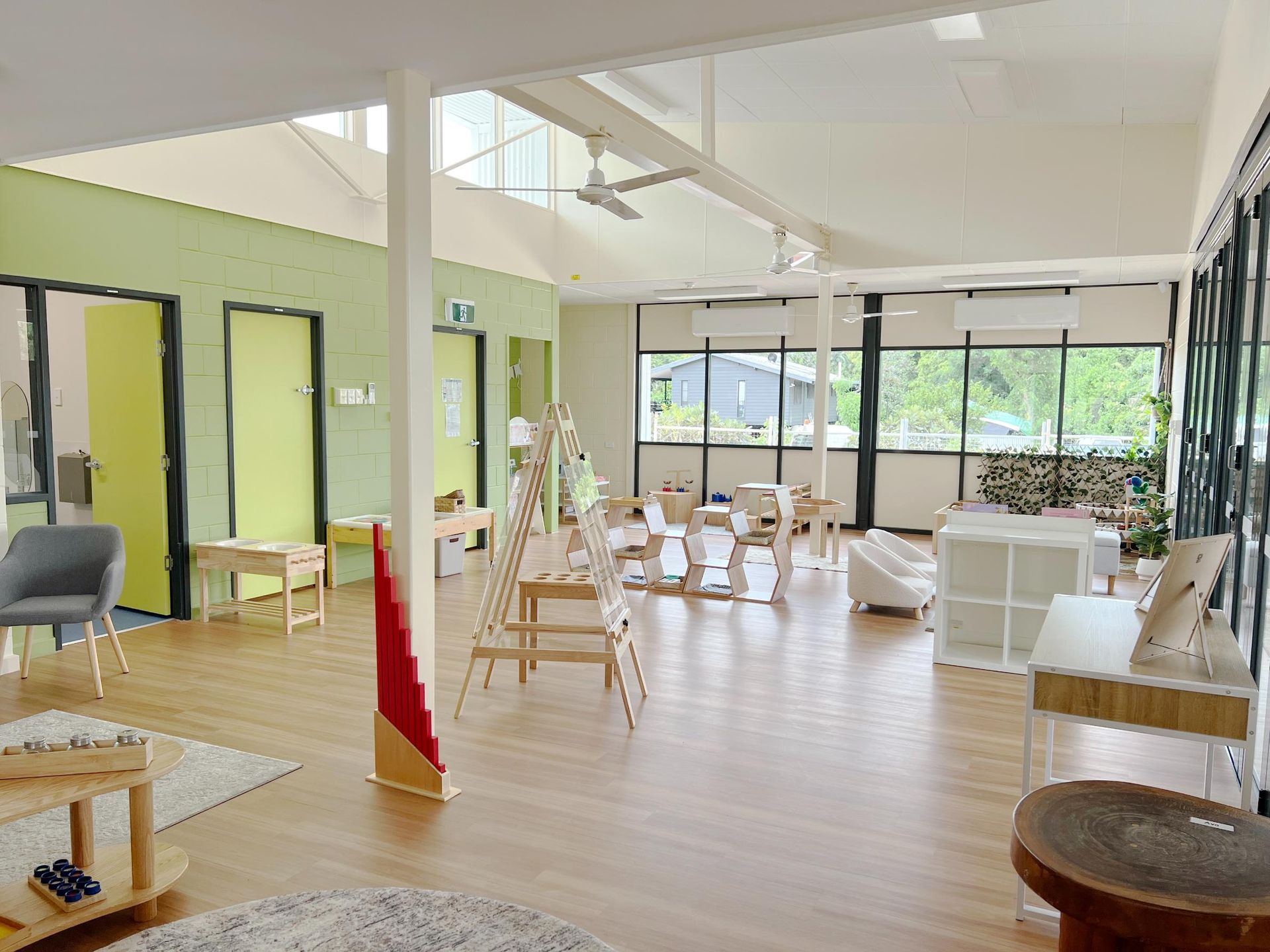 A playground featuring a large, flower-shaped sun shade structure, surrounding play equipment, and surrounding trees.