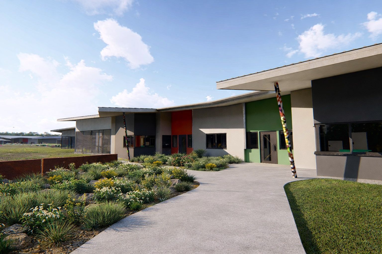 A paved path curves toward a modern building with colorful green and orange panels, set against a sunny, blue-sky landscape.
