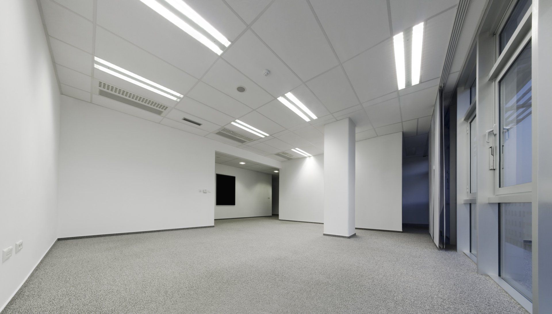 a large empty room with a carpeted floor and white walls .
