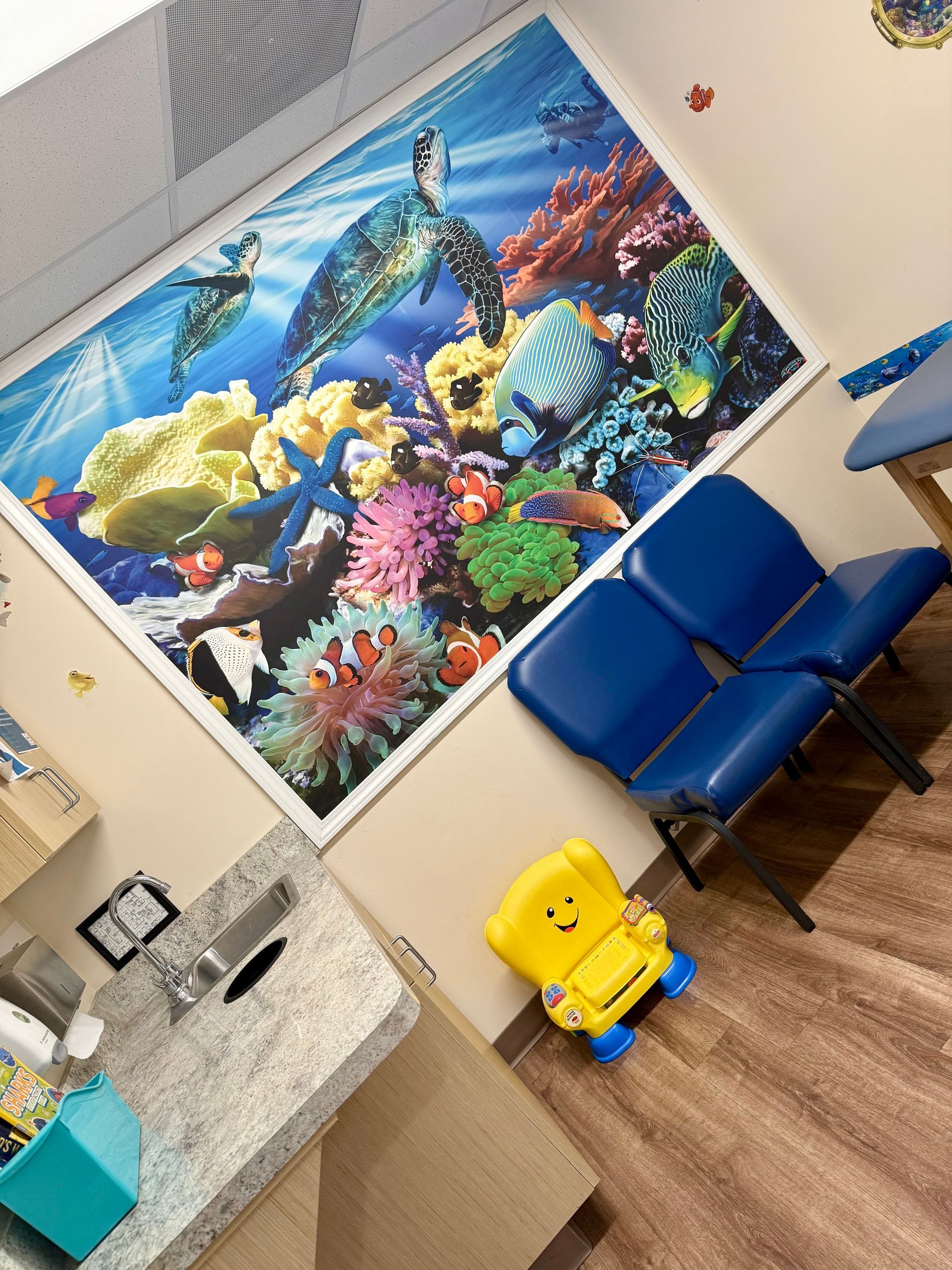 A waiting room with a picture of a coral reef on the wall