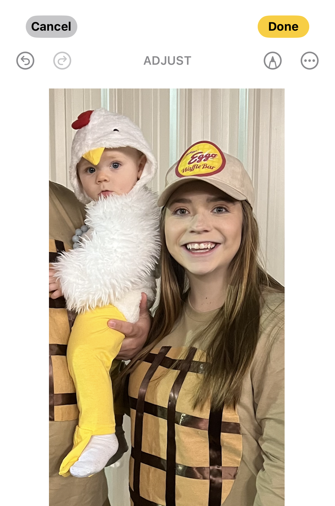 A woman wearing a cat in the hat is holding a baby.