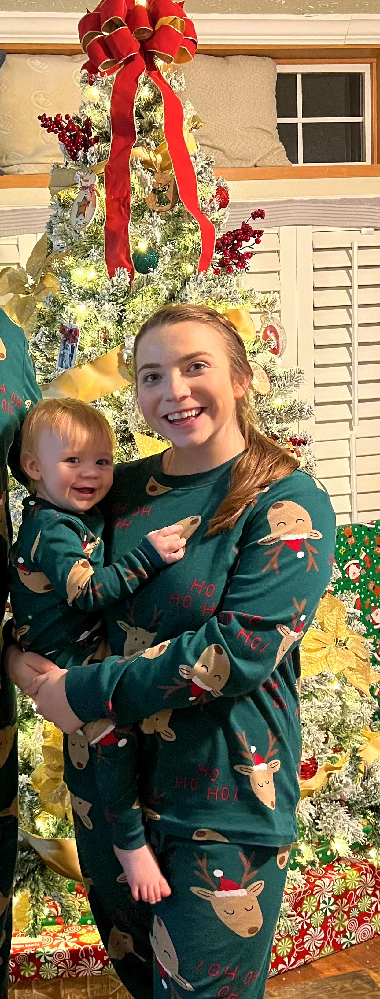 A woman wearing a cat in the hat is holding a baby.