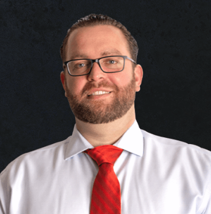 A man with a beard and glasses in a red tie and white shirt, personal injury & defense attorney in PA, NJ & FL.