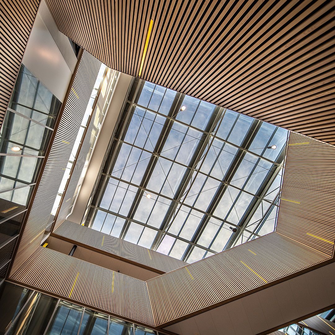 Modern atrium ceiling with glass skylight and wavy striped wall panels