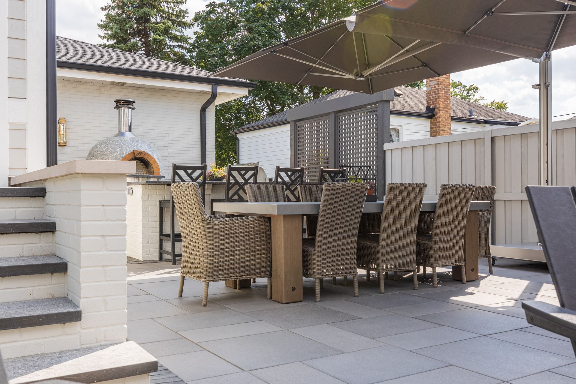 A patio with a table and chairs and an umbrella.