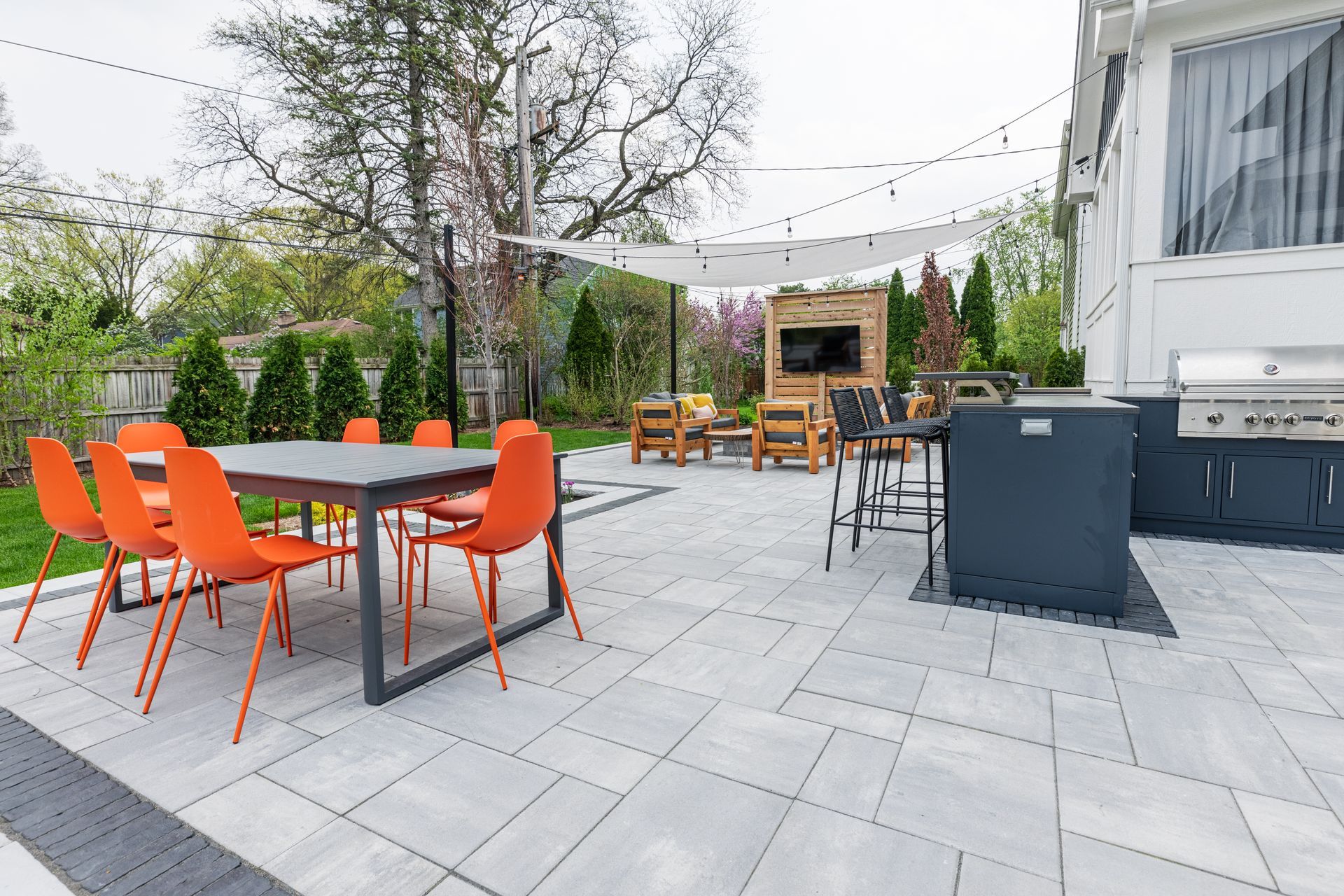 A patio with a table and chairs and a grill.