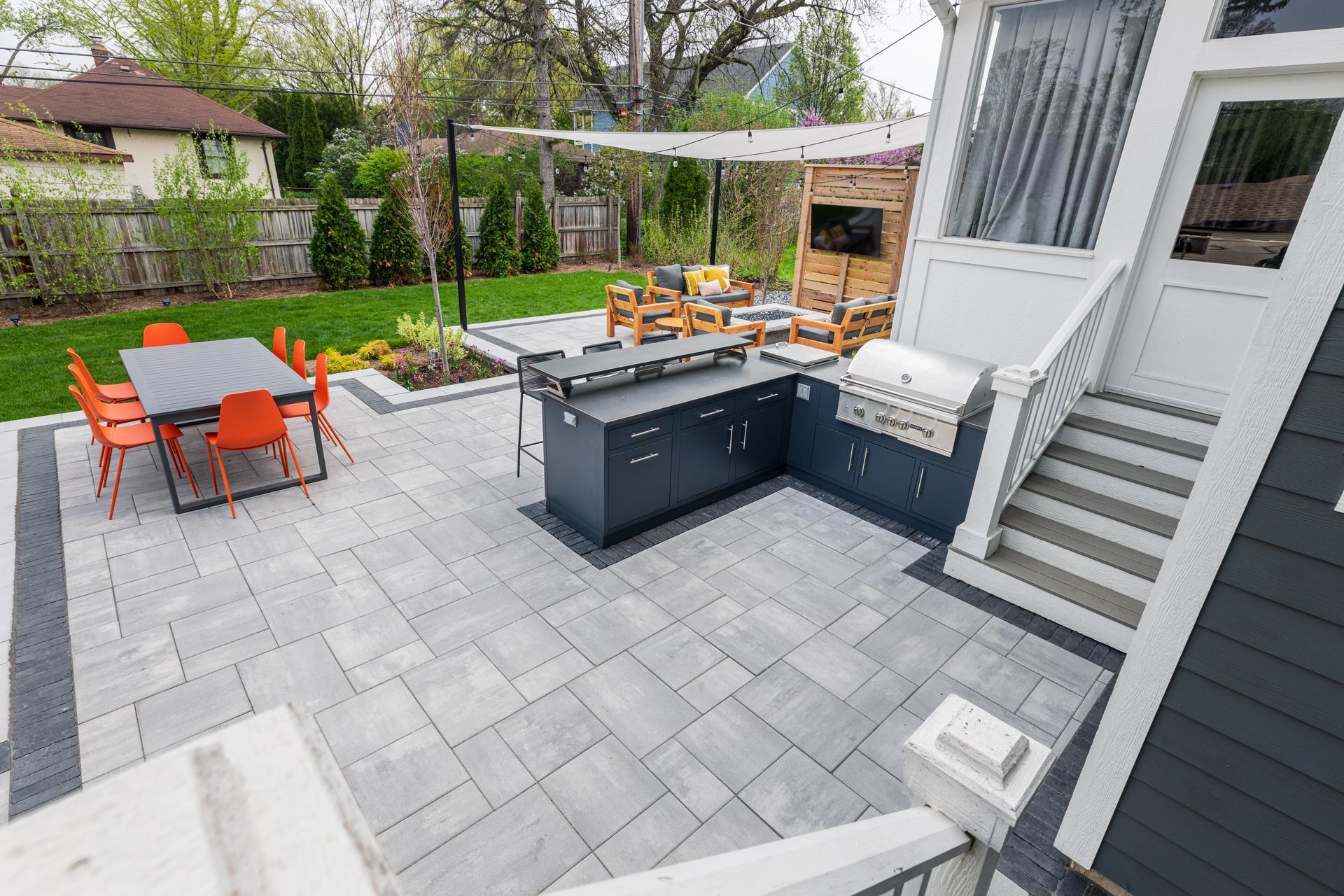A patio with a table and chairs and a grill.