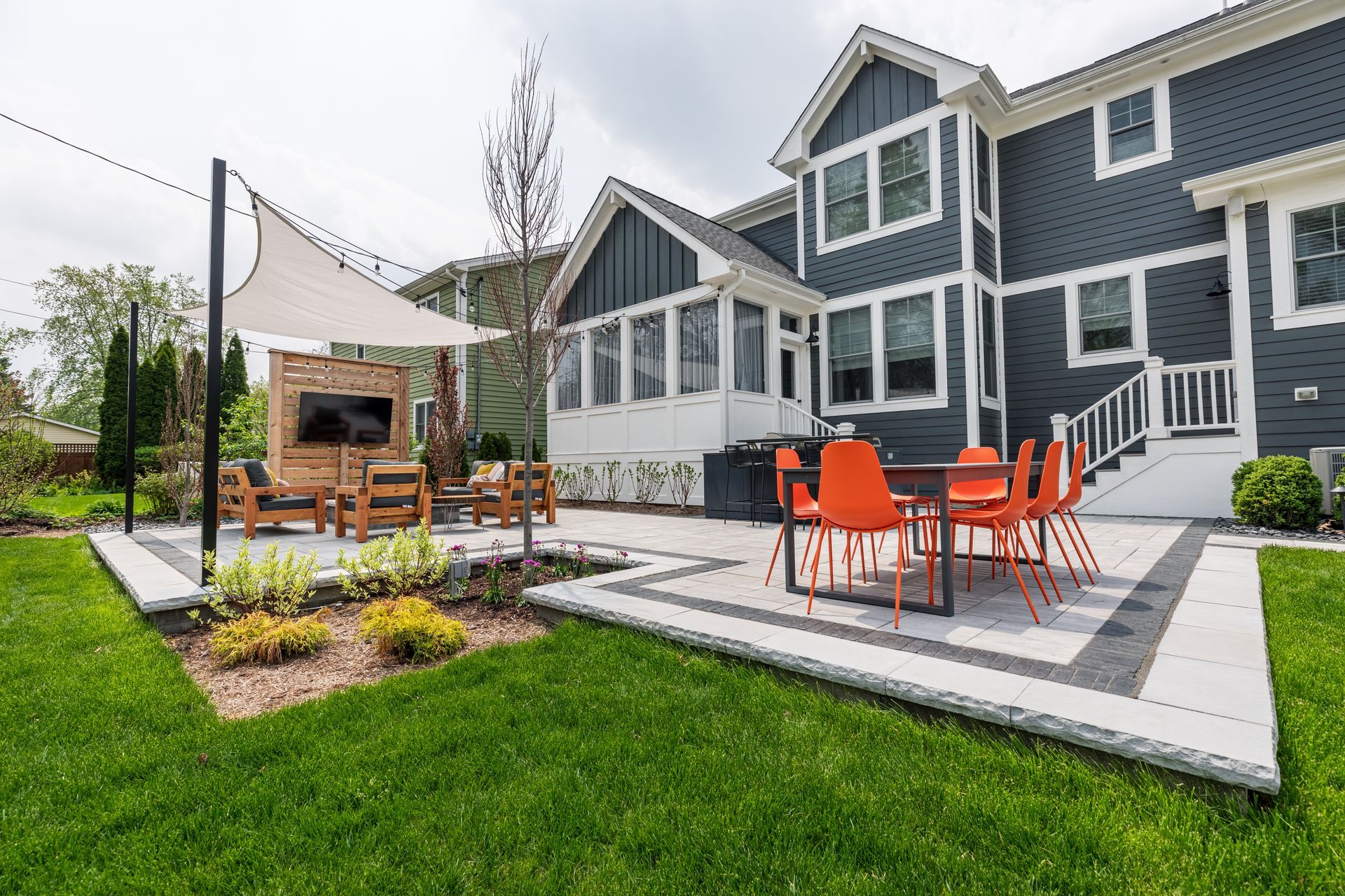 A large house with a patio with a table and chairs in front of it.
