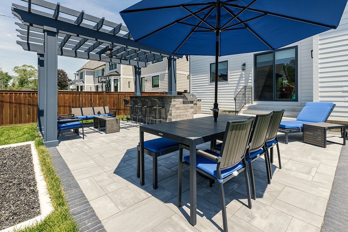 A patio with a table and chairs under an umbrella.