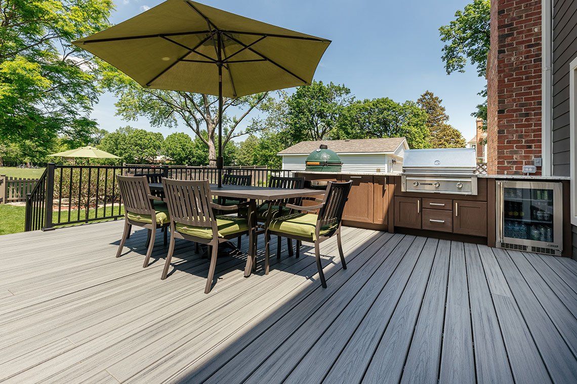 There is a table and chairs on the deck with an umbrella.