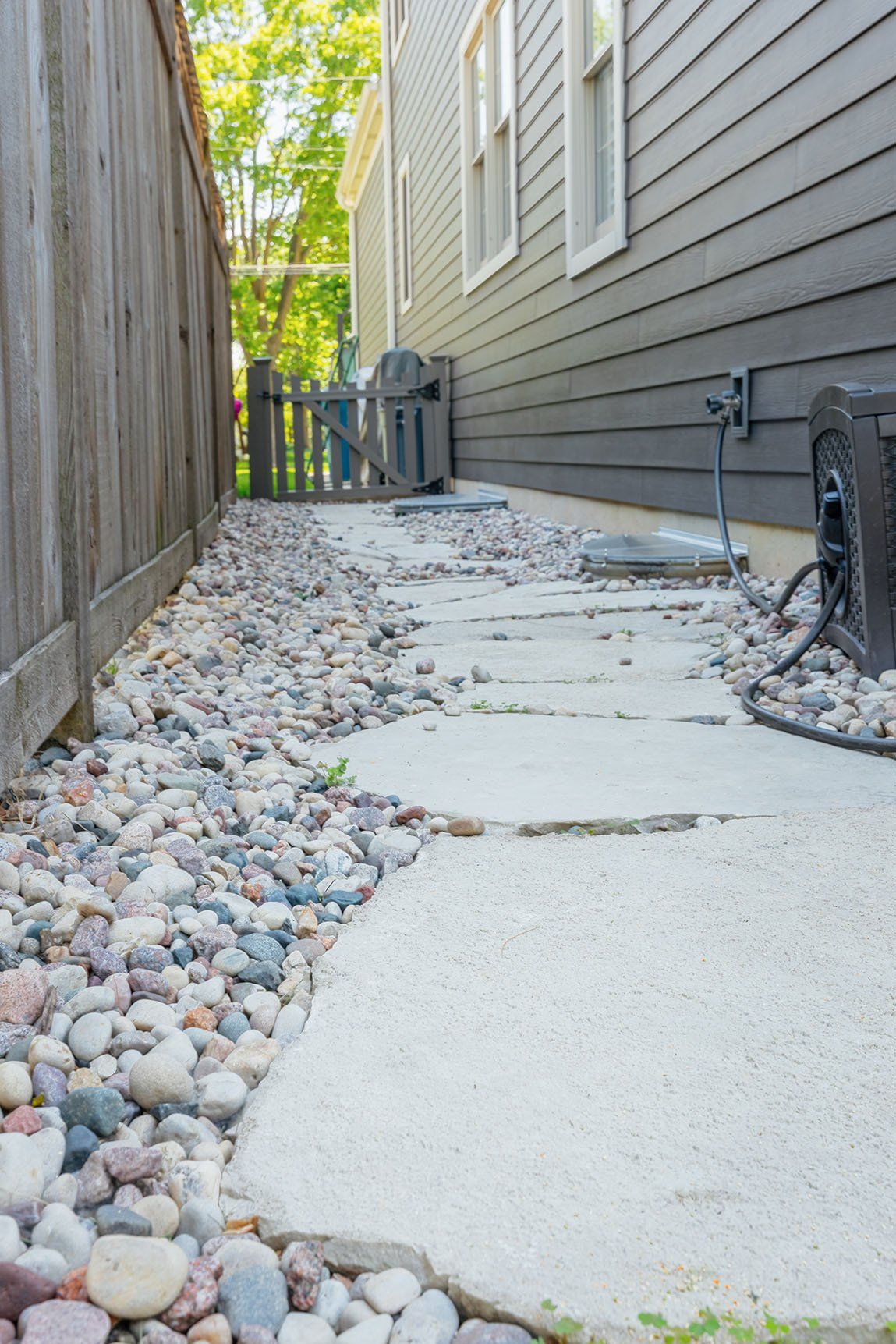 A stone walkway leading to the side of a house.