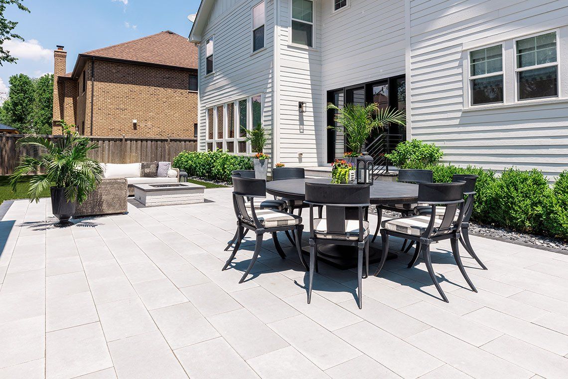 A patio with a table and chairs in front of a house.
