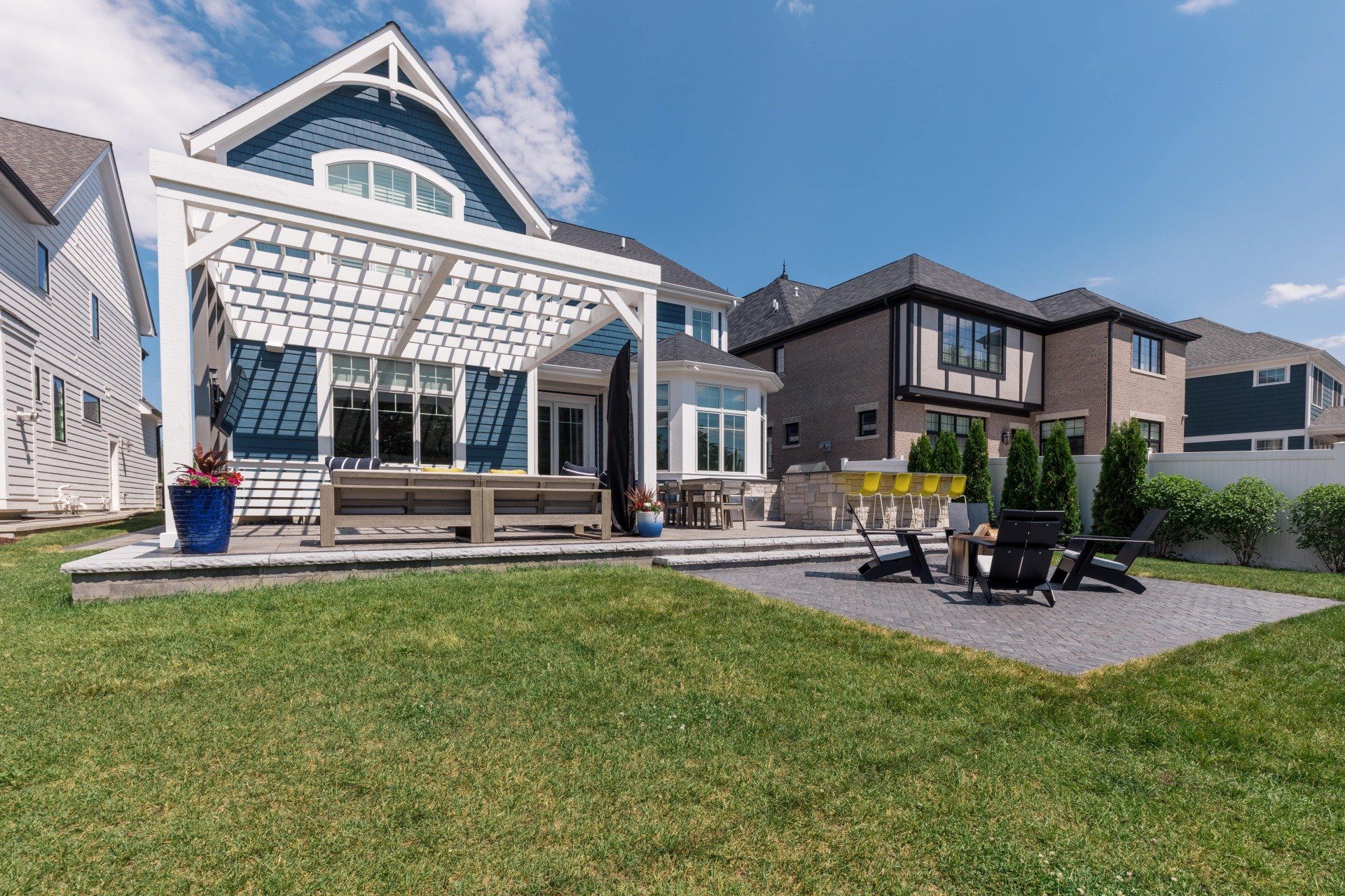 The backyard of a house with a pergola and a patio.