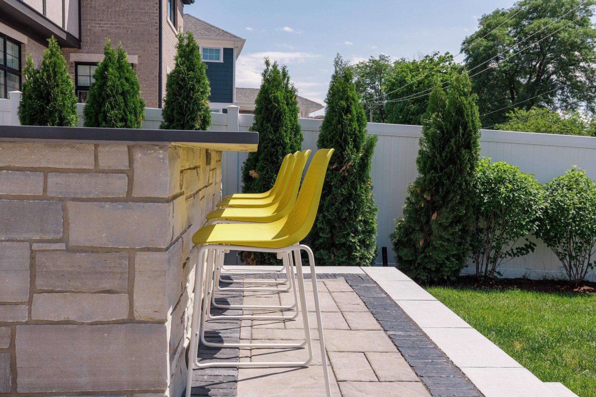 A row of yellow chairs sitting next to a brick wall