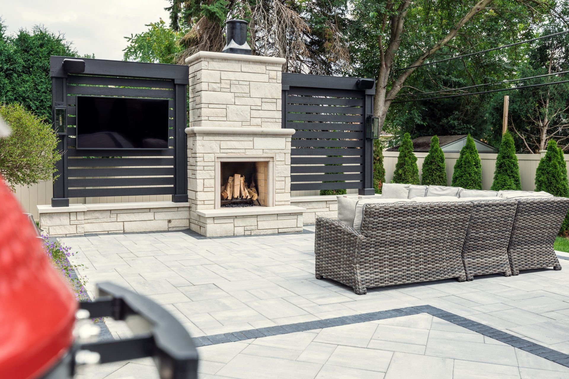 A patio with a fireplace , couch , and television.