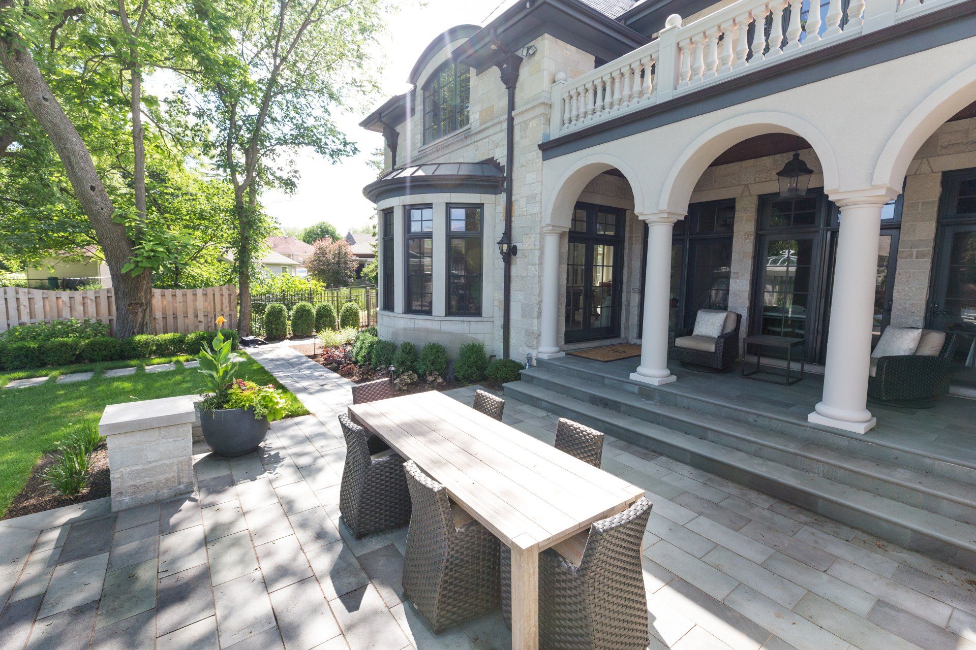 A large house with a patio with a table and chairs in front of it.