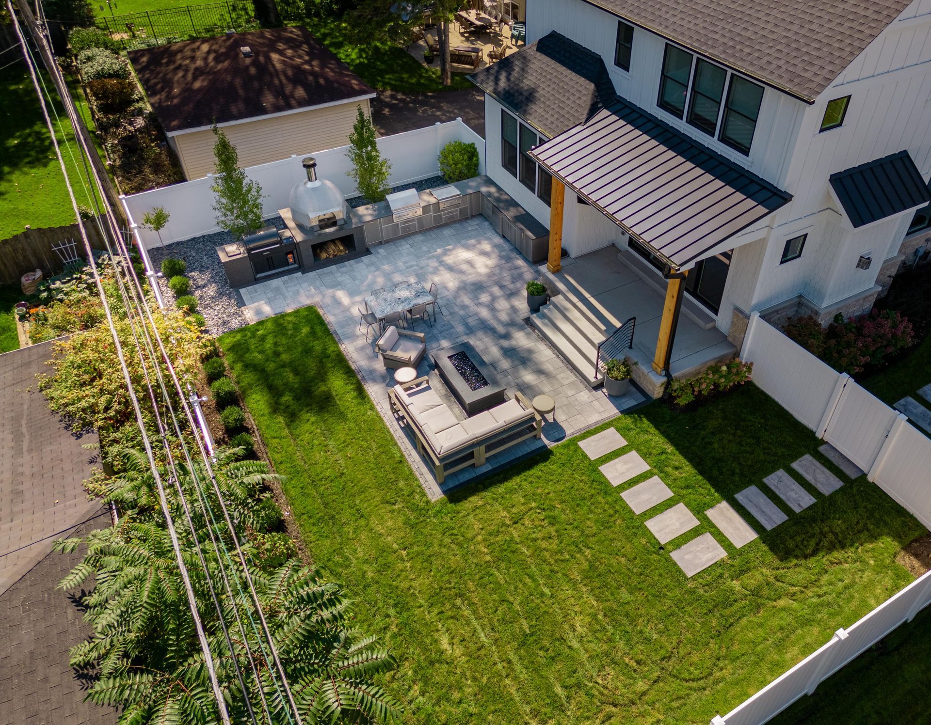 An aerial view of a house with a fire pit in the backyard.