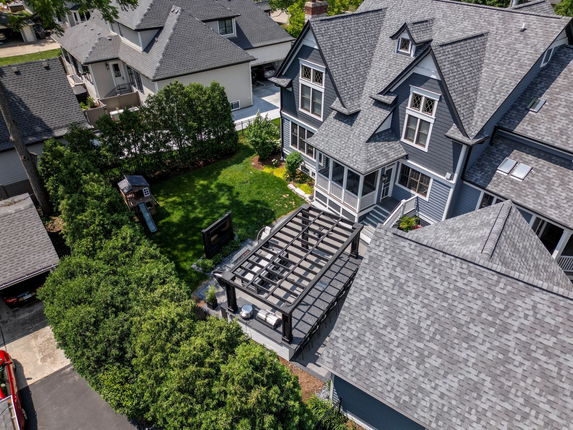 An aerial view of a house with a pergola in the backyard.