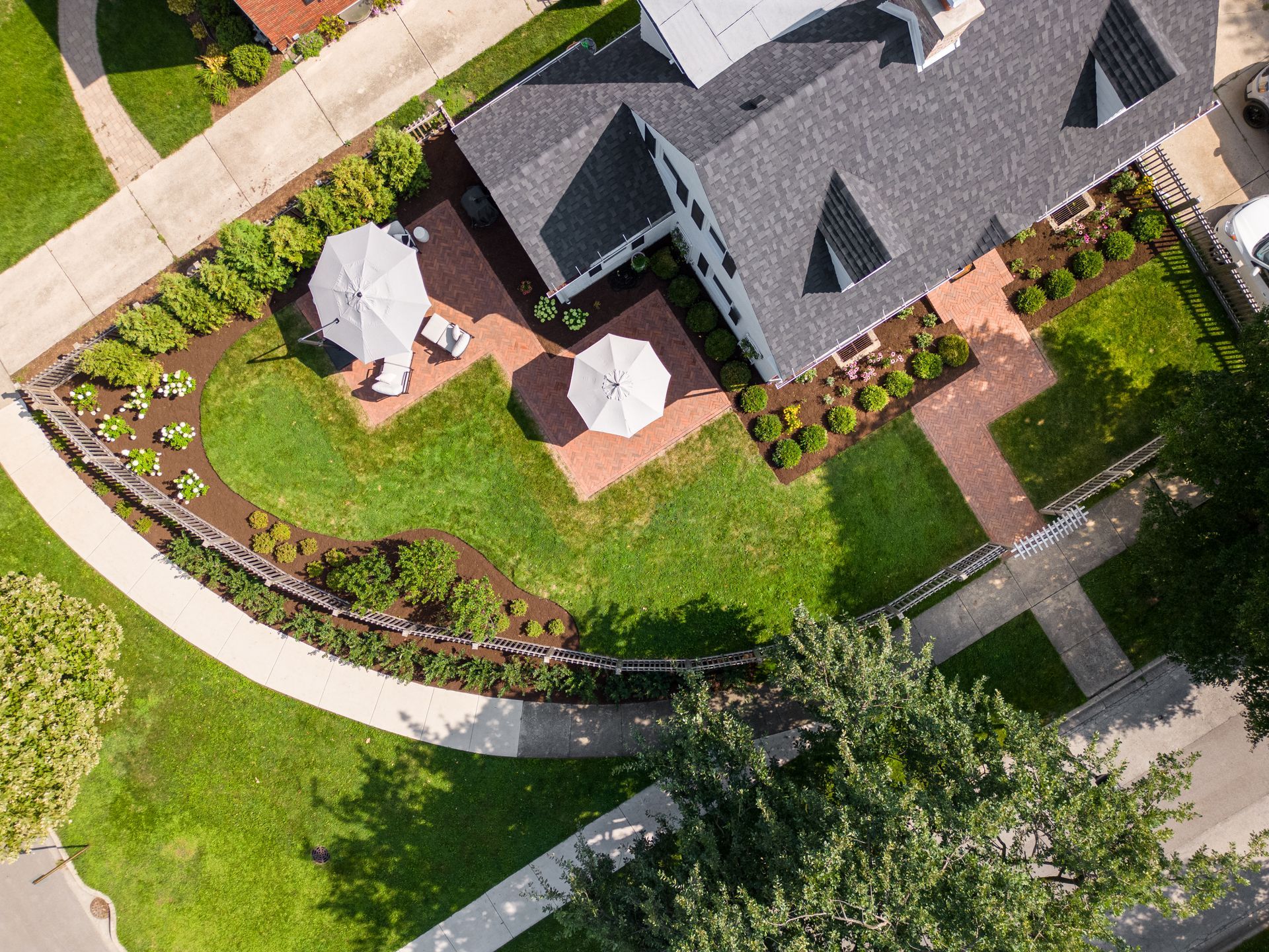 An aerial view of a house with umbrellas in the backyard.