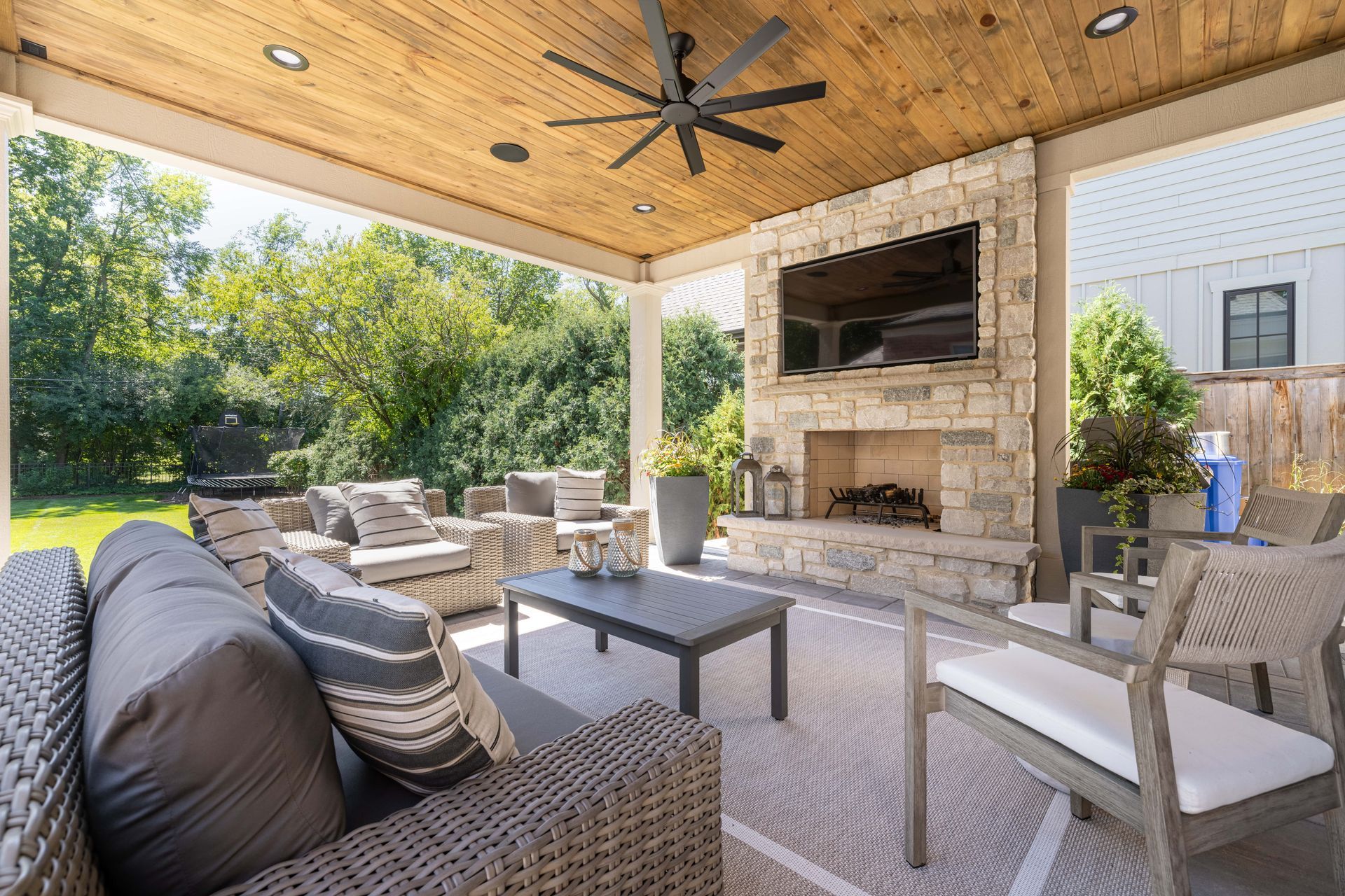 A living room with a fireplace and a ceiling fan.