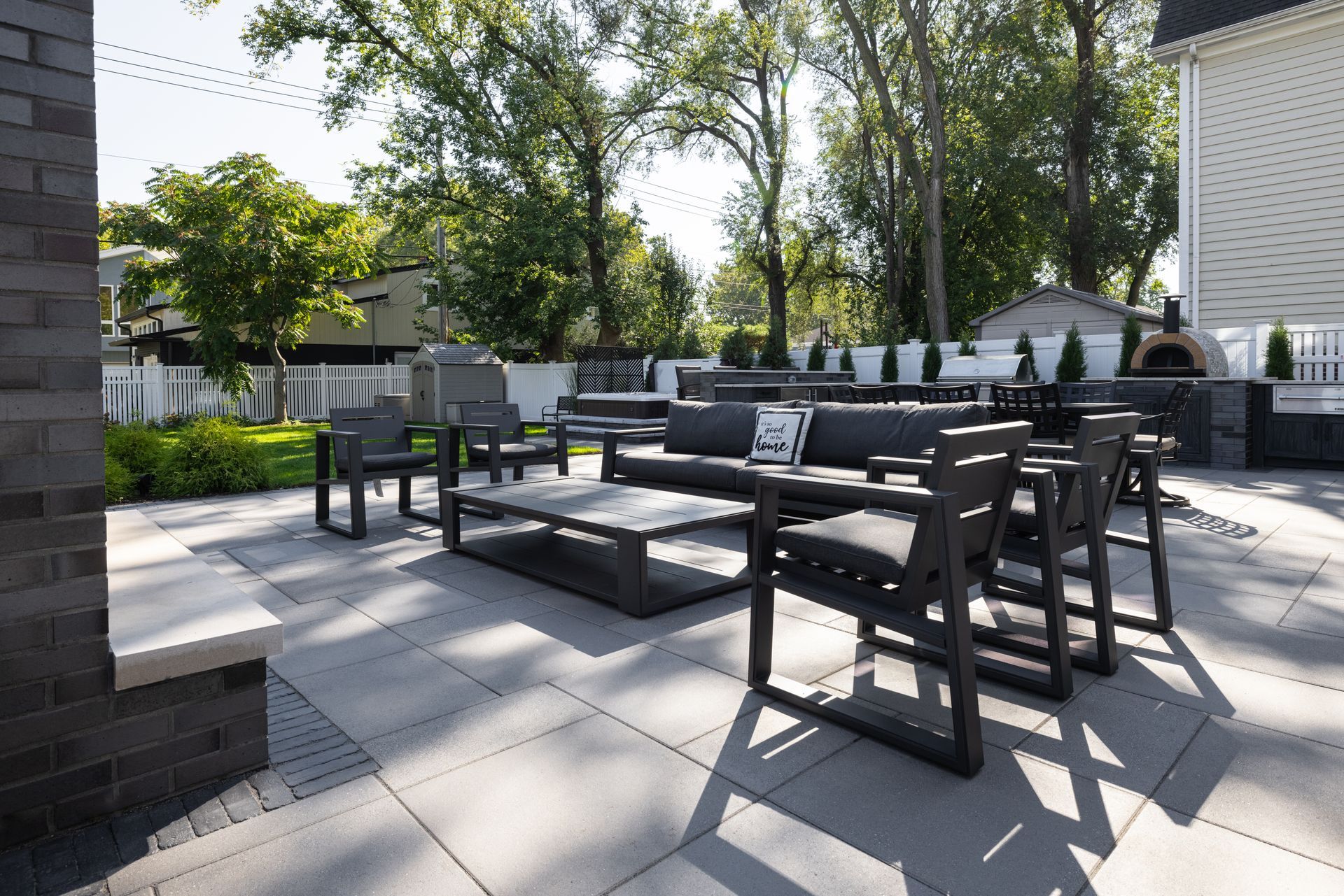 A patio with a couch , chairs , and a table.