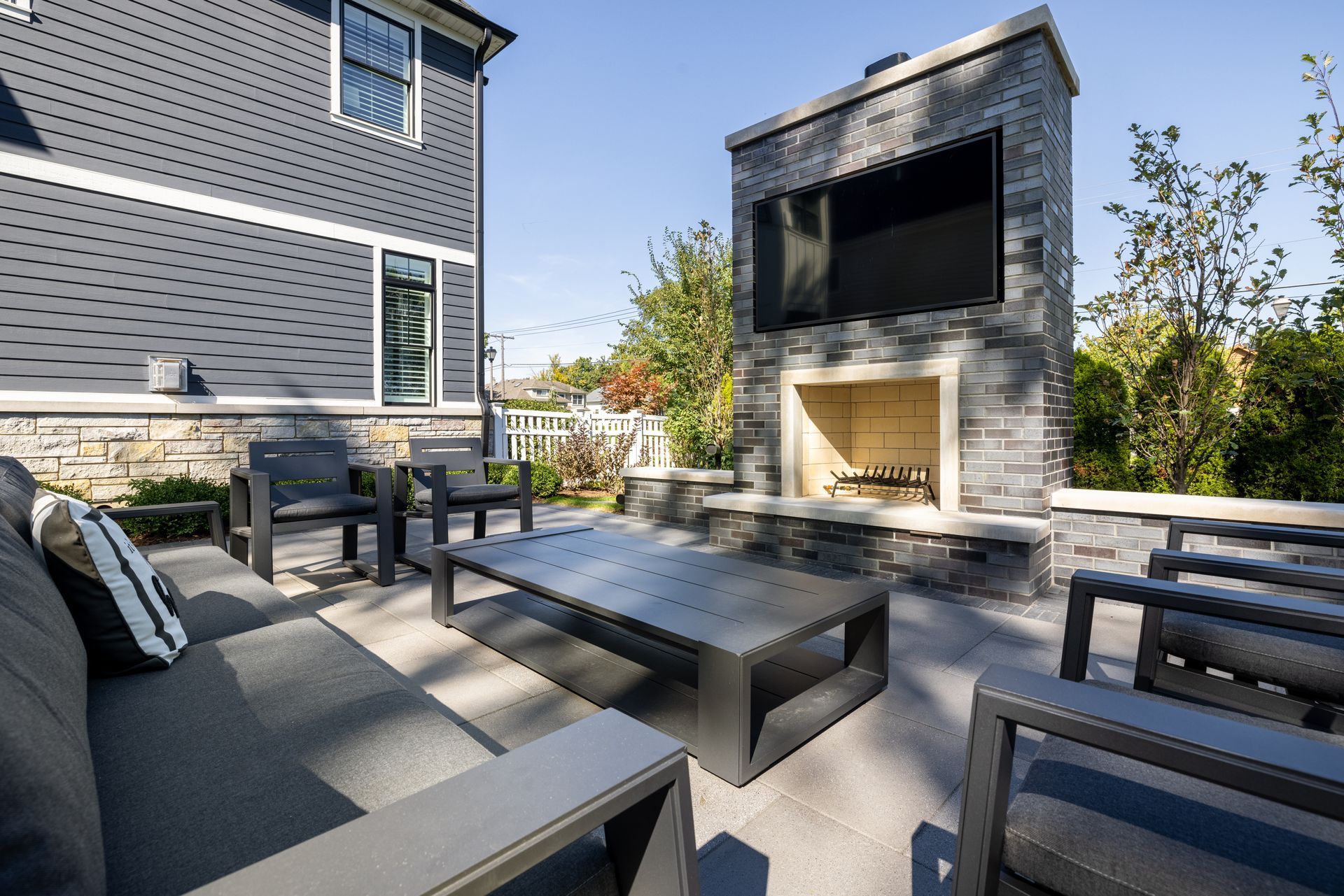 A patio with a fireplace and a flat screen tv.