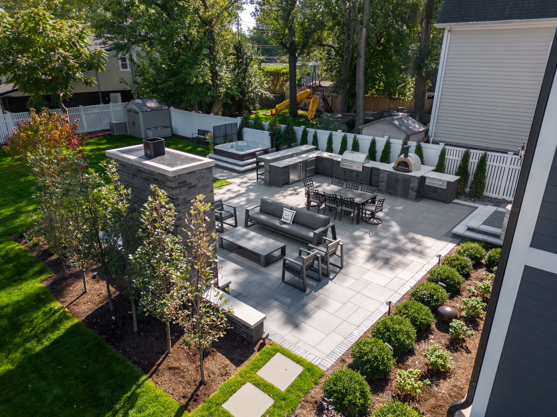 An aerial view of a backyard filled with furniture and a fireplace.