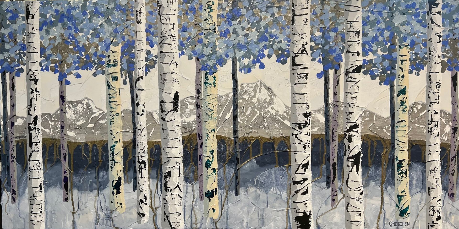 Birch trees in front of snowy mountains with blue-toned foliage.