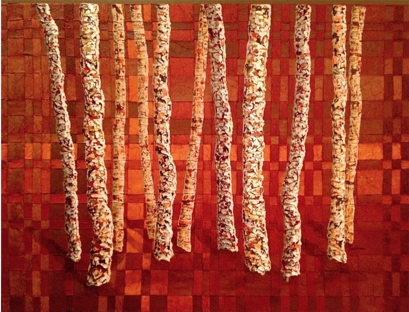 Birch trees with textured bark against a red checkered background.