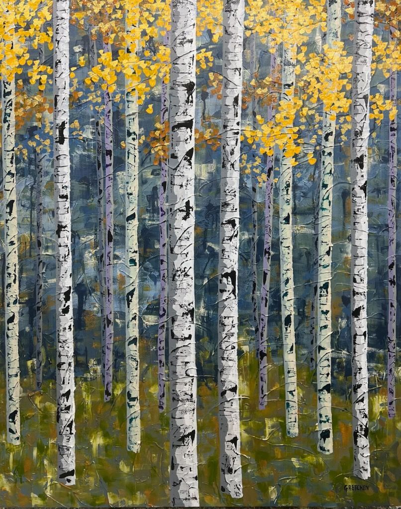 Purple and gray tree trunks in a forest before a reddish mountain under a pale yellow sky.