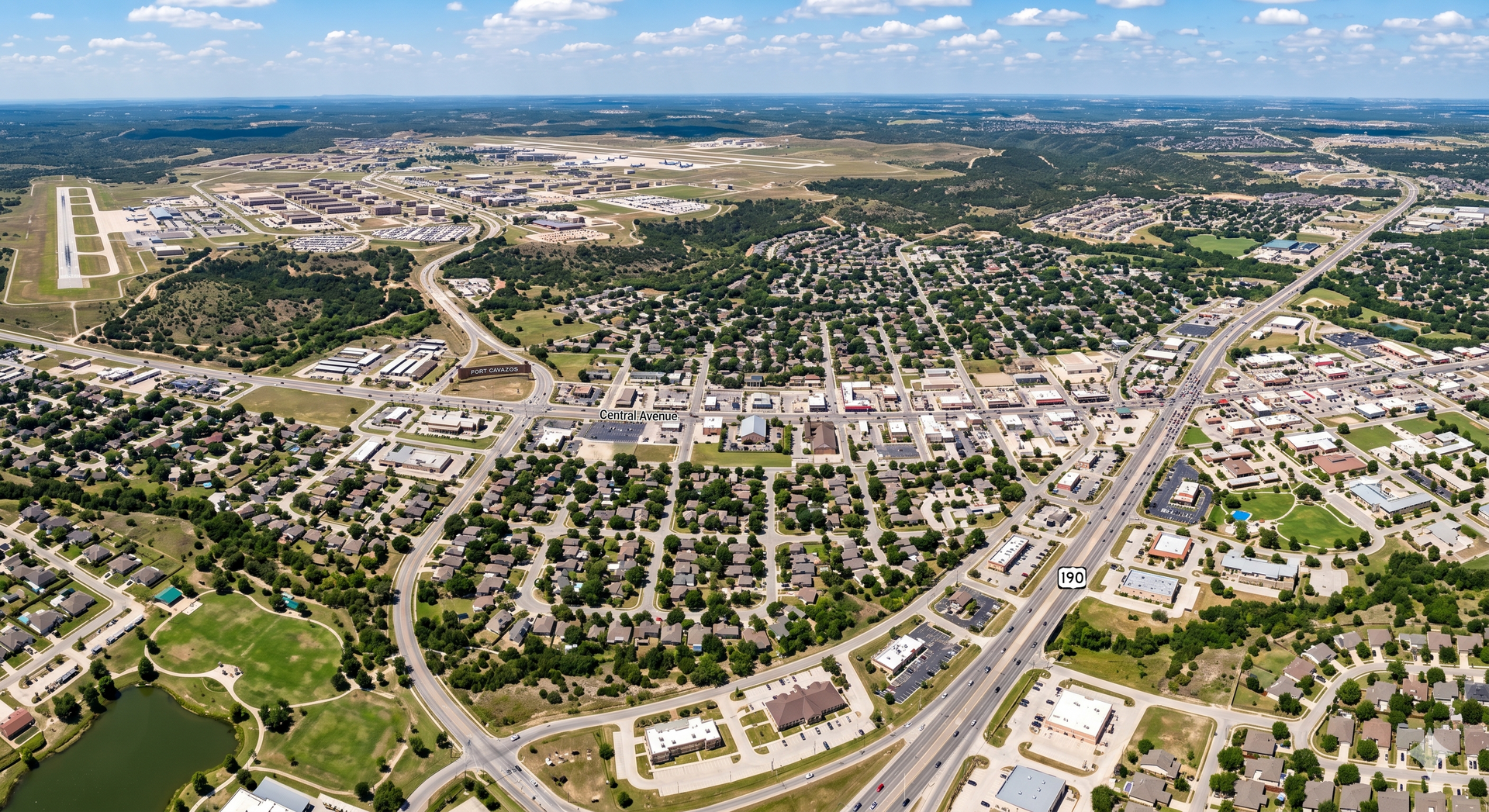 Aerial view of Killeen neighborhood with curved streets, houses, trees, and distant city skyline