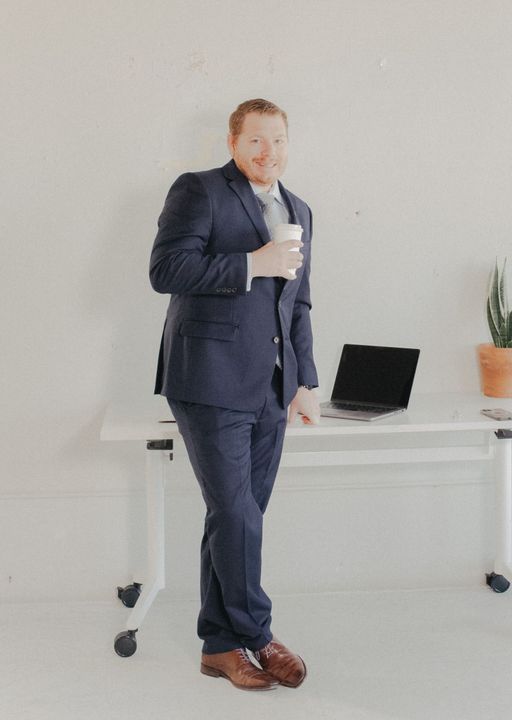 A man in a suit and bow tie with his arms crossed