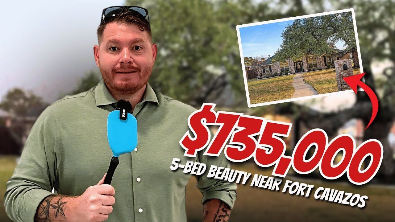 A man is holding a microphone in front of a picture of a house for sale.