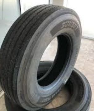 Dos neumáticos están apilados uno encima del otro sobre un piso de baldosas.