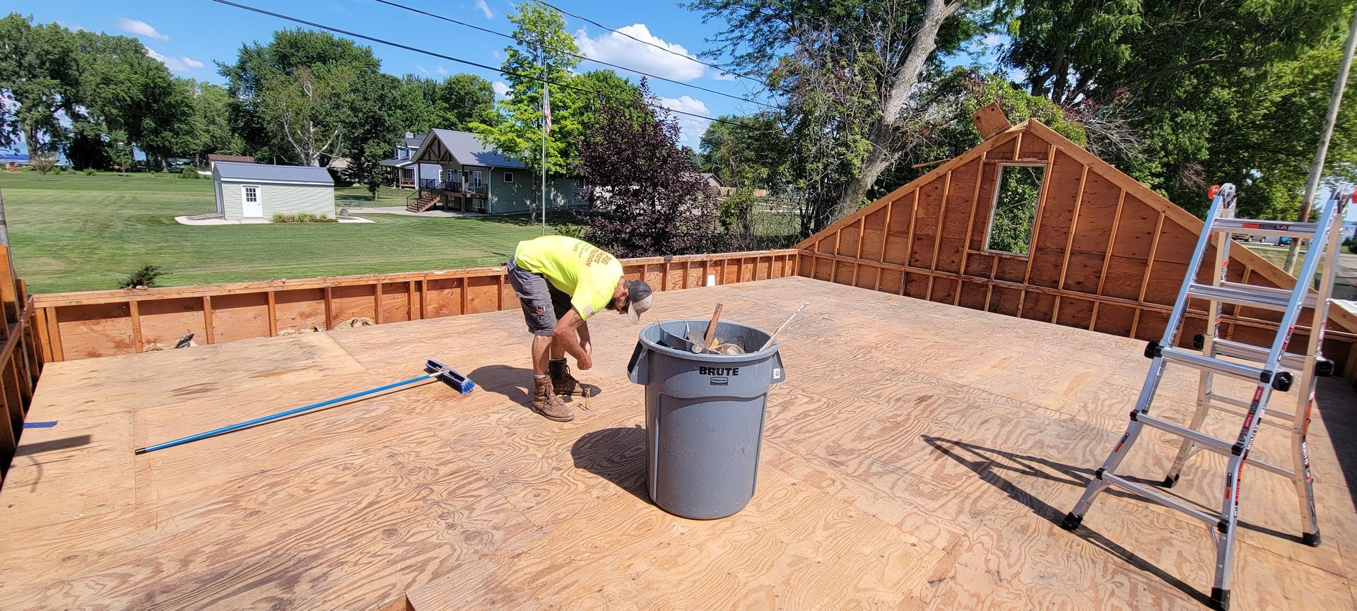 A man is working on a concrete wall in a backyard.