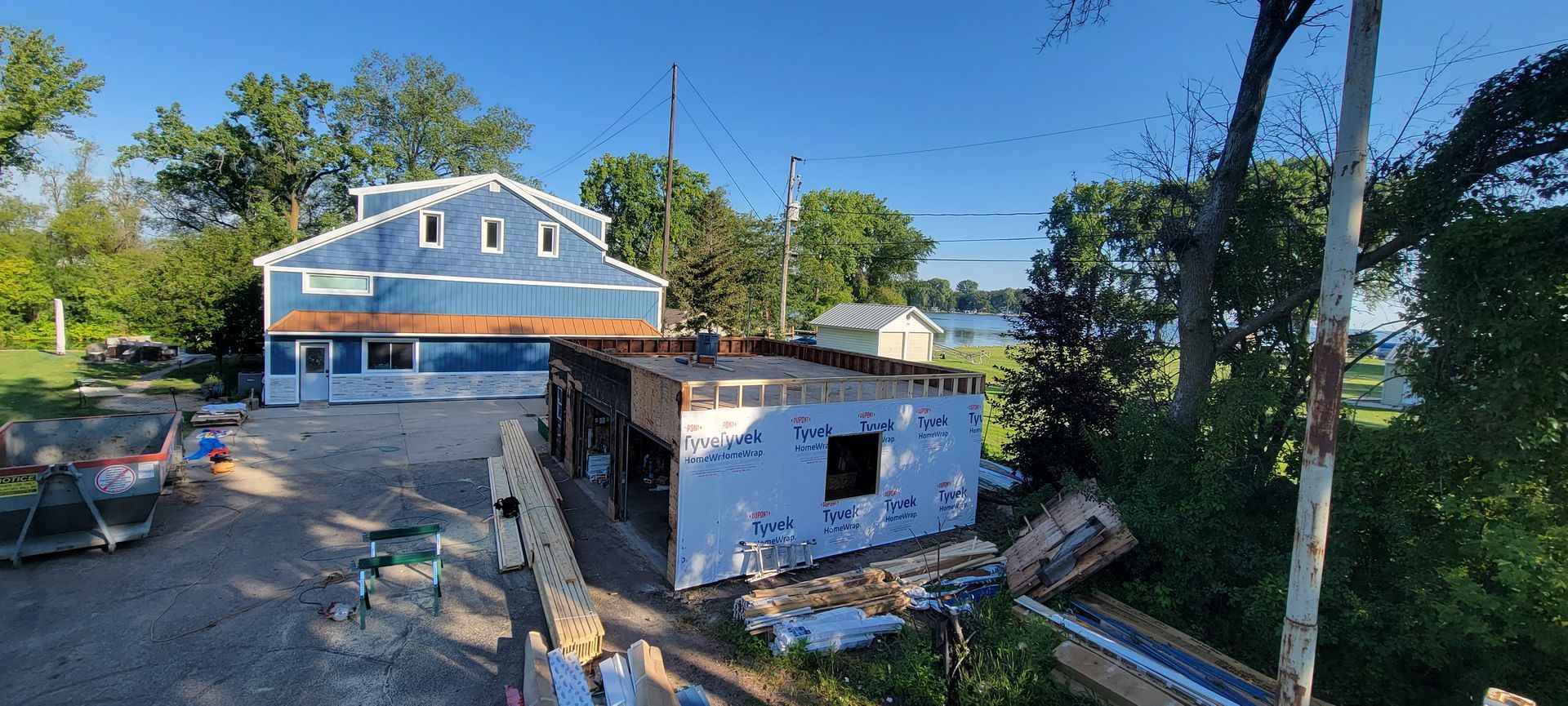An aerial view of a house under construction next to a body of water.