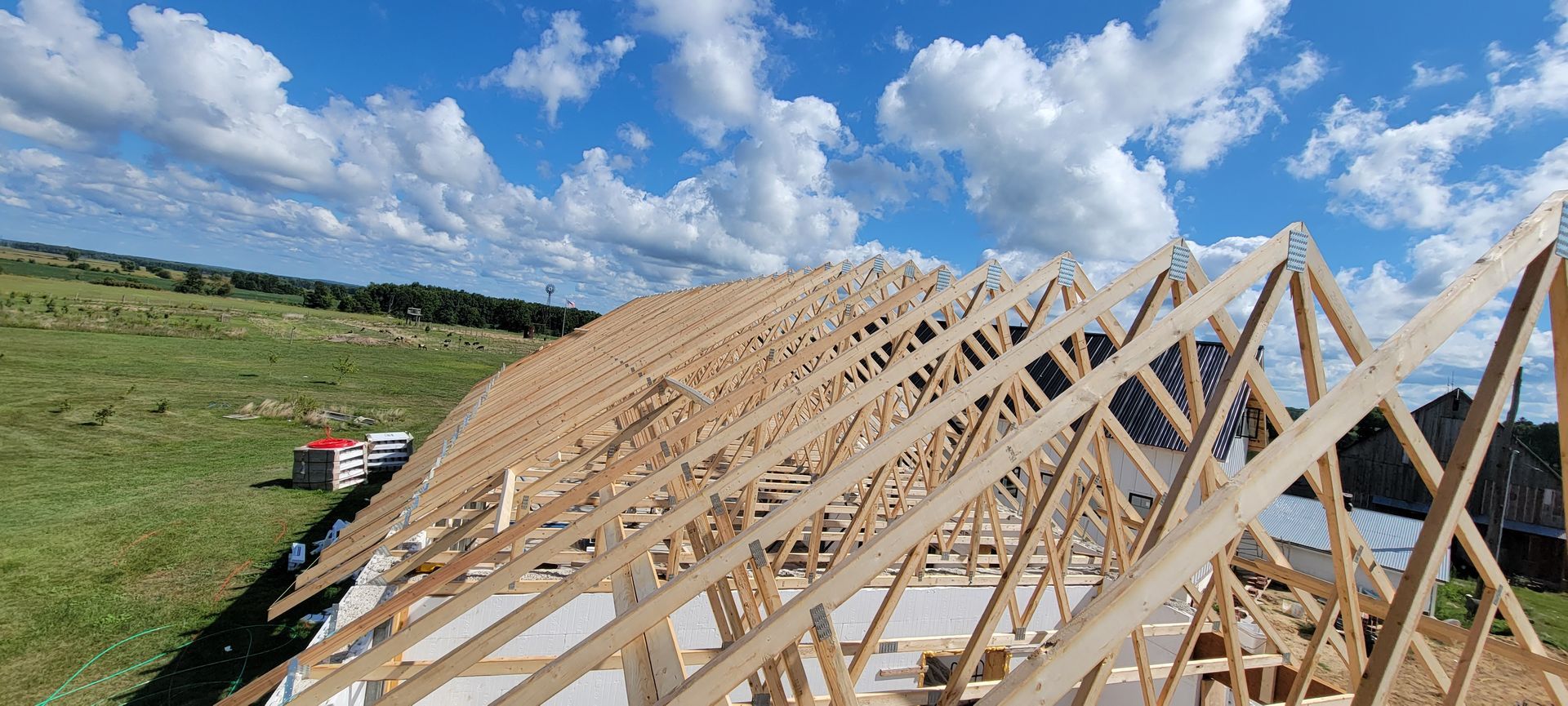 A large wooden structure is being built in a field.