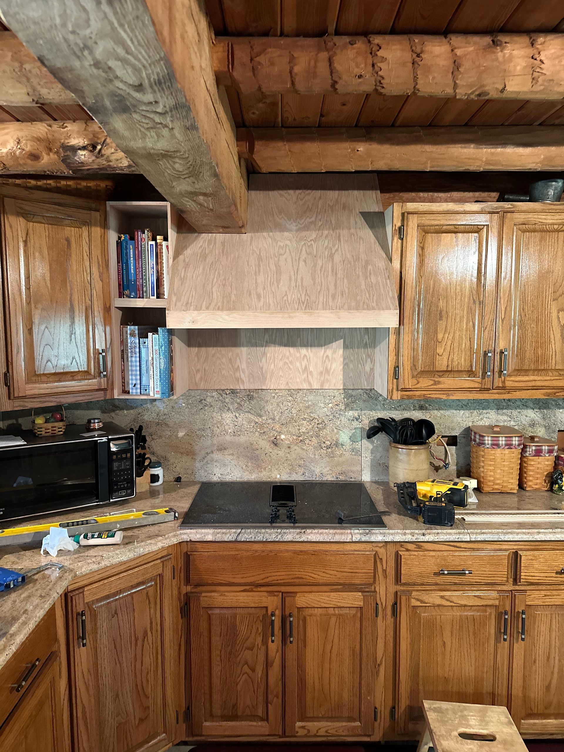A kitchen with wooden cabinets and a stove top oven.