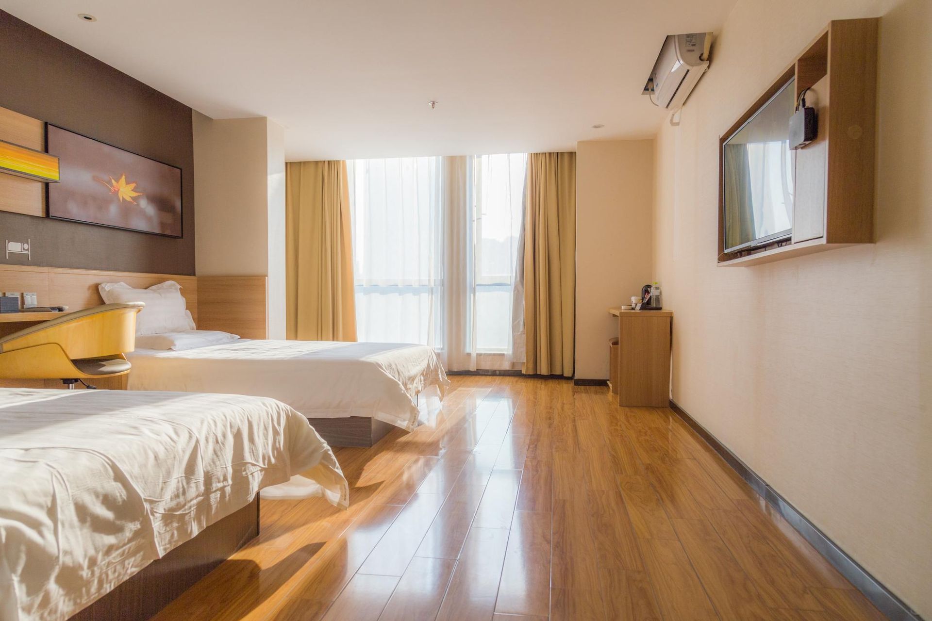 A hotel room with two beds and a flat screen tv.