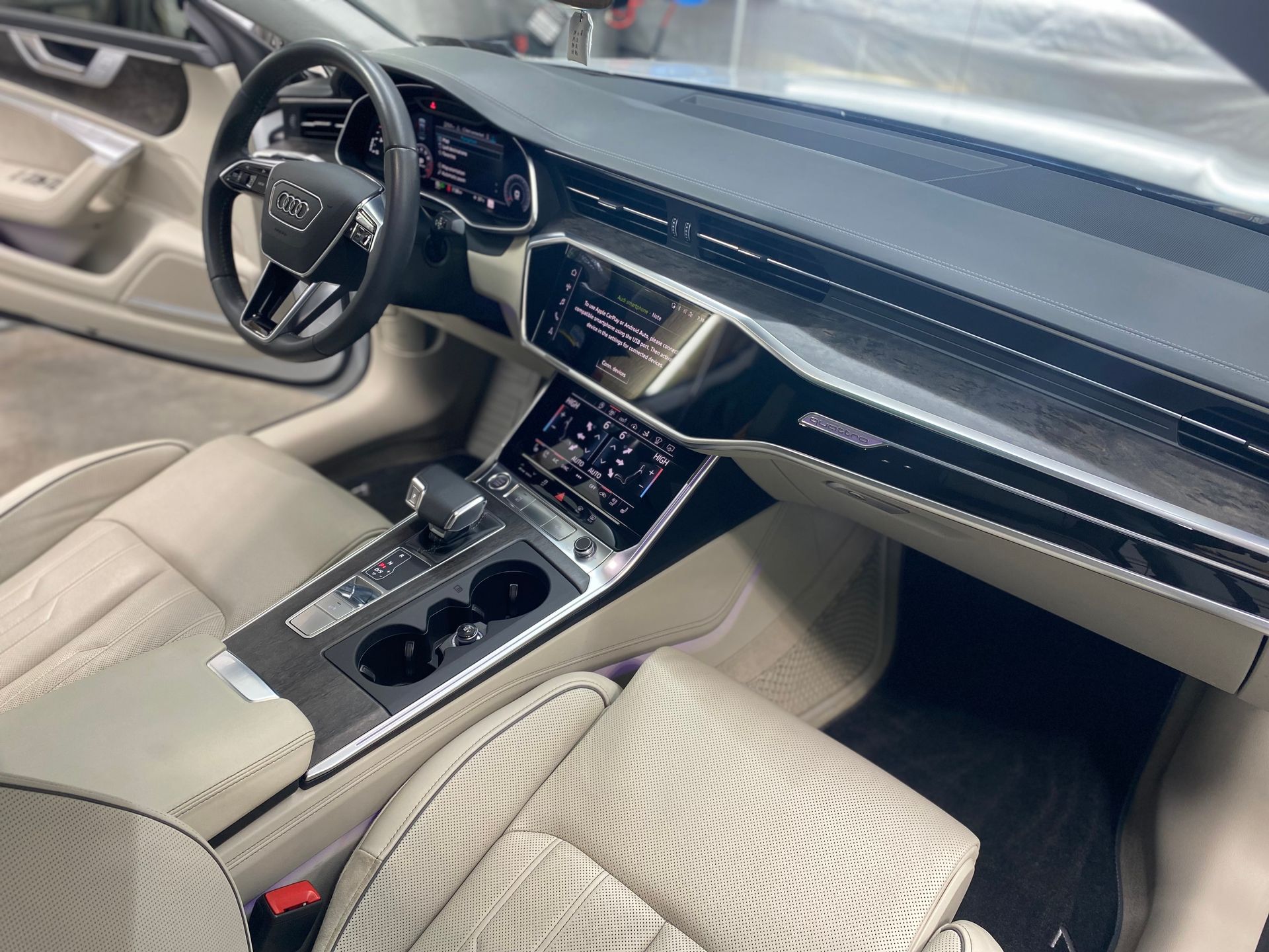 Interior view of a modern Audi, with tan leather seats and a sleek dashboard.