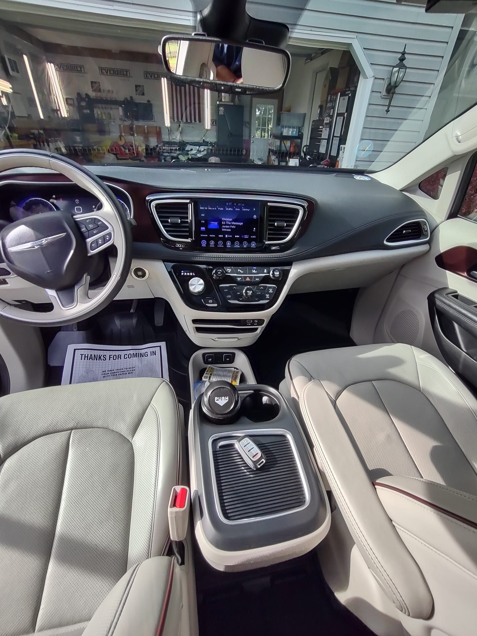 Interior view of a Chrysler Pacifica minivan, showing the dashboard, seats, and center console.
