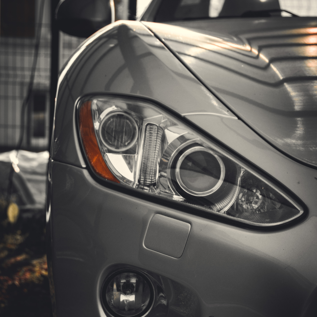 A close up of a silver car 's headlight