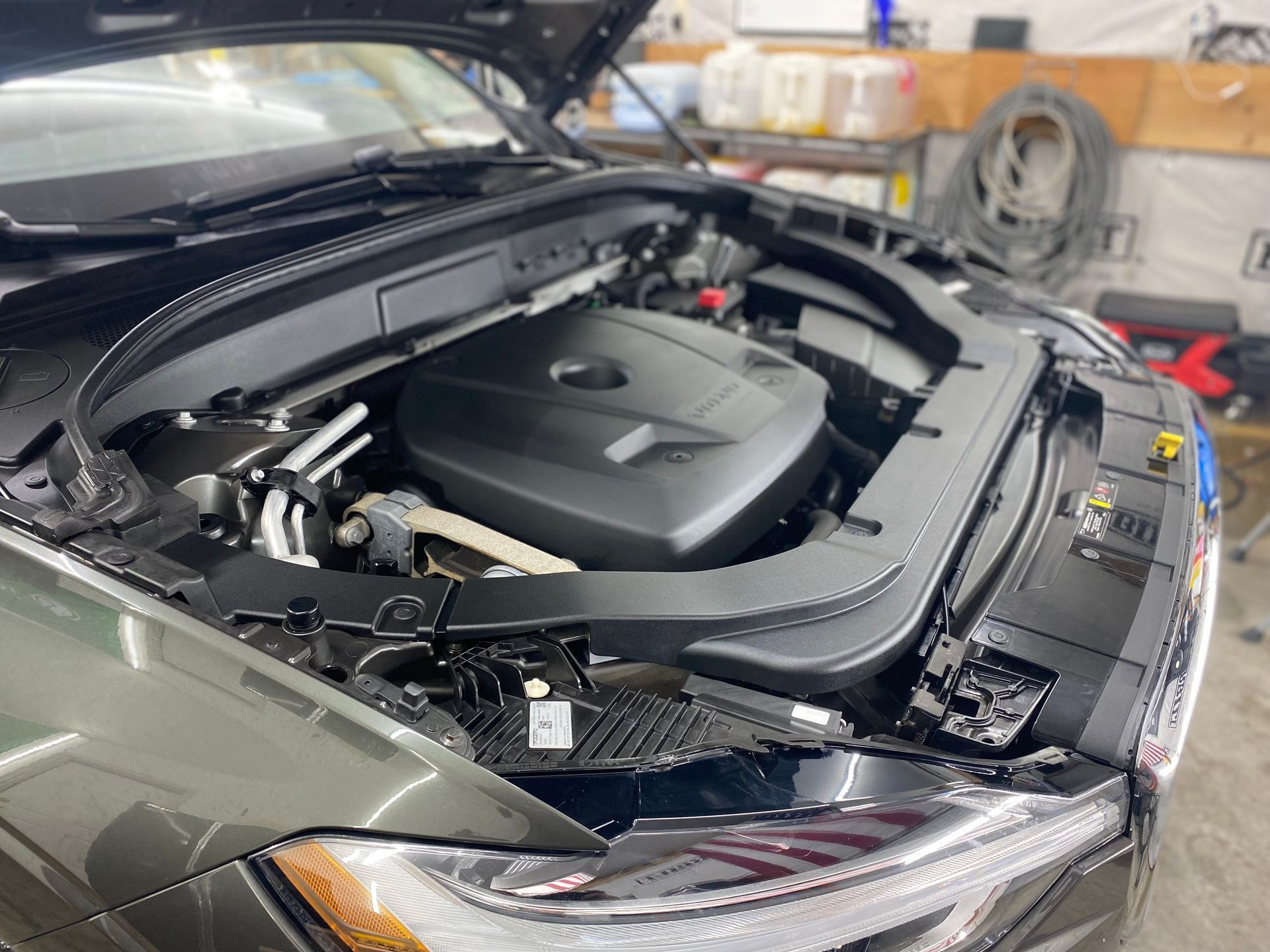 A black car with the hood up and the engine visible